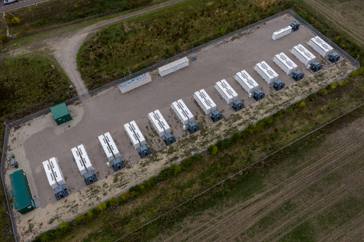 Aerial view of Chapel Farm Energy Park featuring rows of white battery storage containers on a gravel site surrounded by fields in Luton England United Kingdom. Aerial view of Chapel Farm Energy Park featuring rows of white battery storage containers on a gravel site surrounded by fields in Luton England United Kingdom.