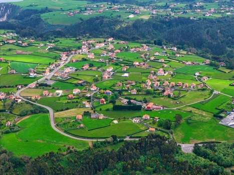 Aerial view of a rural village with houses scattered among lush green meadows and winding roads in Cudillero Asturias Spain.