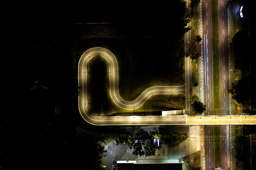 Aerial view of the illuminated Hilde Archenhold Brucke pedestrian bridge at night featuring a curved path and light trails on the adjacent road in Berlin Berlin Germany. Aerial view of the illuminated Hilde Archenhold Brucke pedestrian bridge at night featuring a curved path and light trails on the adjacent road in Berlin Berlin Germany.