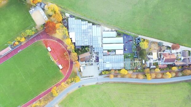 Aerial view of a sports field and greenhouses in Germany. Aerial view of a sports field and greenhouses in Germany.