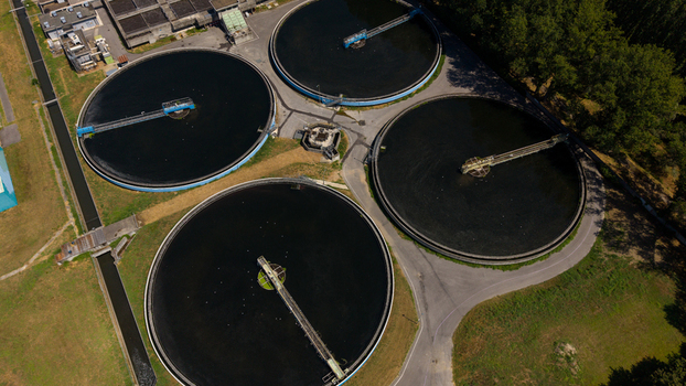 Aerial view of a wastewater treatment plant featuring large circular sedimentation tanks and industrial infrastructure in Milan Lombardy Italy. Aerial view of a wastewater treatment plant featuring large circular sedimentation tanks and industrial infrastructure in Milan Lombardy Italy.
