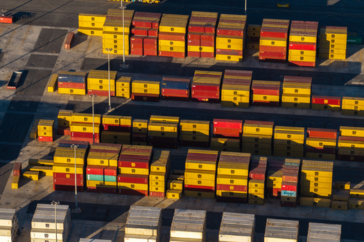 Civitavecchia Lazio Italy 23 August 2026 Aerial view of Civitavecchia Port featuring rows of stacked yellow and red shipping containers under bright sunlight.