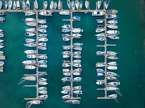 Aerial view of Bangor Harbour and Town with boats docked in orderly rows within the marina surrounded by calm turquoise water in Bangor Northern Ireland United Kingdom.