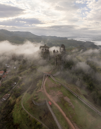 Aerial view of Belogradchik Fortress surrounded by dramatic rock formations and low hanging clouds in the Balkan Mountains in Belogradchik Vidin Bulgaria. Aerial view of Belogradchik Fortress surrounded by dramatic rock formations and low hanging clouds in the Balkan Mountains in Belogradchik Vidin Bulgaria.