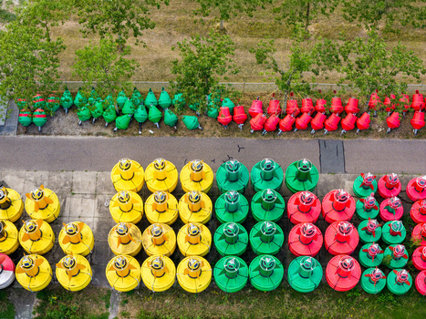 Aerial view of Rijkswaterstaat Harderhaven featuring rows of colorful yellow green and red navigation buoys stored on a paved surface in Zeewolde Flevoland Netherlands.