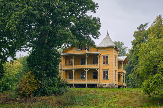 Ronneby Sweden 11 September 2025 View of Brunssparken featuring a historic yellow wooden villa with ornate balconies surrounded by lush green trees and parkland. Ronneby Sweden 11 September 2025 View of Brunssparken featuring a historic yellow wooden villa with ornate balconies surrounded by lush green trees and parkland.