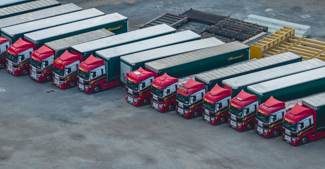 Loriol sur Drome Auvergne Rhone Alpes France 26 July 2026 Aerial view of a fleet of red Bernard semi trucks with green trailers parked in an organized pattern at a logistics yard.