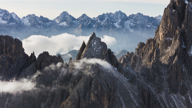 Aerial view of the jagged peaks of the Cadini group with swirling clouds and mist in the heart of the Dolomites Auronzo di Cadore Veneto Italy. Aerial view of the jagged peaks of the Cadini group with swirling clouds and mist in the heart of the Dolomites Auronzo di Cadore Veneto Italy.