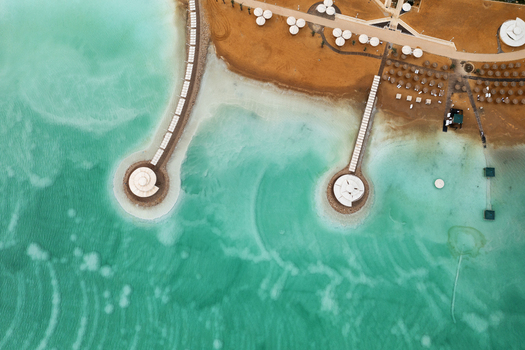 Aerial view of pale turquoise waters swirl around sandy peninsulas their white tipped edges contrasting sharply with the golden sands Ein Bokek South District Israel. Aerial view of pale turquoise waters swirl around sandy peninsulas their white tipped edges contrasting sharply with the golden sands Ein Bokek South District Israel.