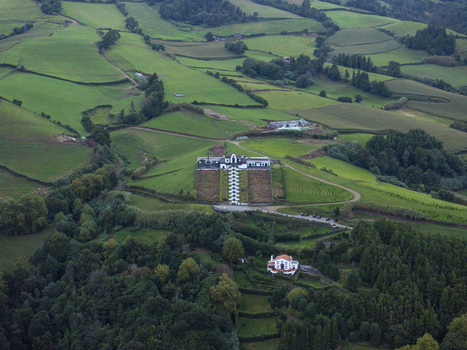 Aerial view of the Chapel of Nossa Senhora da Paz situated on a hill surrounded by lush green fields and forests in Vila Franca Do Campo Acores Portugal. Aerial view of the Chapel of Nossa Senhora da Paz situated on a hill surrounded by lush green fields and forests in Vila Franca Do Campo Acores Portugal.