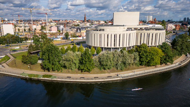 Aerial view of the Opera Nova s cylindrical form reflected in the tranquil waters of the Brda River a modern structure amidst the historic city Bydgoszcz Województwo kujawsko pomorskie Poland. Aerial view of the Opera Nova s cylindrical form reflected in the tranquil waters of the Brda River a modern structure amidst the historic city Bydgoszcz Województwo kujawsko pomorskie Poland.