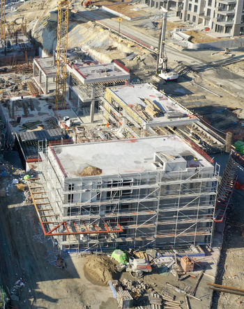 Aerial view of a large construction site featuring buildings under development with scaffolding yellow cranes and heavy machinery in Avcilar Istanbul Turkiye. Aerial view of a large construction site featuring buildings under development with scaffolding yellow cranes and heavy machinery in Avcilar Istanbul Turkiye.