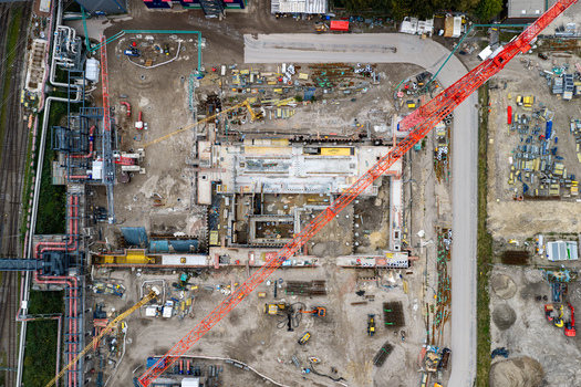 Aerial view of the construction site at Heizkraftwerk Reuter West power plant with a large red tower crane excavation work and industrial machinery in Berlin Berlin Germany.