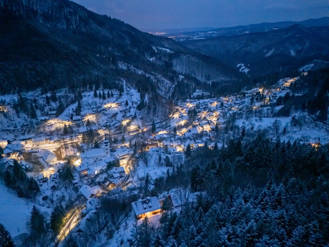 Aerial view of the historic village of Spania Dolina illuminated at night nestled in a snow covered valley among pine forests Spania Dolina Banska Bystrica Regio Slovakia. Aerial view of the historic village of Spania Dolina illuminated at night nestled in a snow covered valley among pine forests Spania Dolina Banska Bystrica Regio Slovakia.