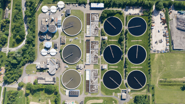 Aerial view of the Rwzi Weurt wastewater treatment plant with circular sedimentation tanks and industrial infrastructure surrounded by green fields in Weurt Gelderland Netherlands. Aerial view of the Rwzi Weurt wastewater treatment plant with circular sedimentation tanks and industrial infrastructure surrounded by green fields in Weurt Gelderland Netherlands.