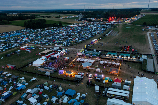 Herzogenaurach Germany 25 July 2025 Aerial view of the Open Beatz Festival featuring a vast campsite illuminated stages and a ferris wheel under a twilight sky. Herzogenaurach Germany 25 July 2025 Aerial view of the Open Beatz Festival featuring a vast campsite illuminated stages and a ferris wheel under a twilight sky.