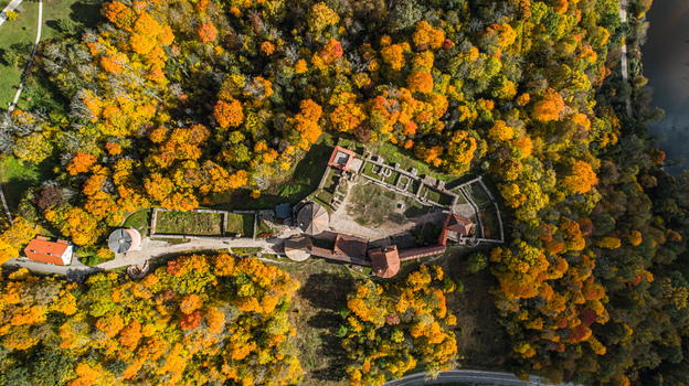 Aerial view of Sigulda Castle ruins surrounded by a dense forest with vibrant autumn foliage and a winding river nearby in Sigulda Sigulda Municipality Latvia. Aerial view of Sigulda Castle ruins surrounded by a dense forest with vibrant autumn foliage and a winding river nearby in Sigulda Sigulda Municipality Latvia.