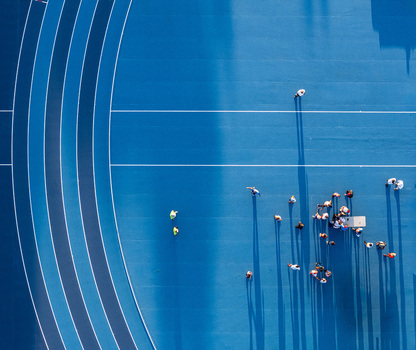Aerial view of a blue athletic track with runners and people gathered on the field in Santo Domingo Distrito Nacional Dominican Republic.
