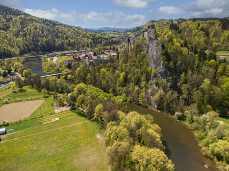 Aerial view of Orava Castle perched on a high rock cliff above the Orava river surrounded by lush green forests and rolling hills in Dolny Kubin Zilinsky kraj Slovakia. Aerial view of Orava Castle perched on a high rock cliff above the Orava river surrounded by lush green forests and rolling hills in Dolny Kubin Zilinsky kraj Slovakia.