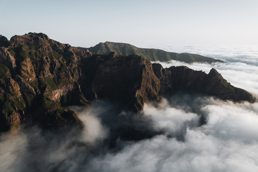 Aerial view of rugged peaks piercing through a sea of ethereal clouds Pico do Areeiro Madeira Portugal.