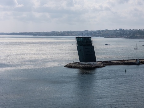 Alges Lisbon Portugal 25 July 2026 Aerial view of the Torre VTS de Alges a modern maritime traffic control tower on a breakwater in the Tagus River with boats and coastline.