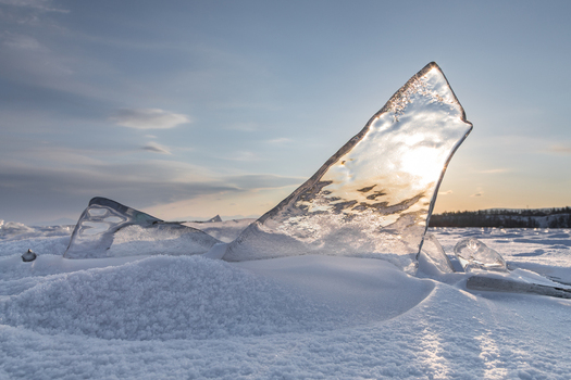 View of transparent ice shards on the frozen surface of Lake Baikal at sunset in Severobaykalsk Buryatia Russia. View of transparent ice shards on the frozen surface of Lake Baikal at sunset in Severobaykalsk Buryatia Russia.