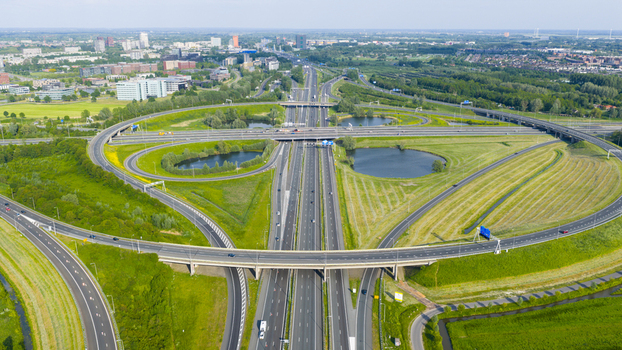 Aerial view of Knooppunt Oudenrijn highway interchange with complex road networks green fields and circular ponds under a clear sky Utrecht Utrecht Netherlands. Aerial view of Knooppunt Oudenrijn highway interchange with complex road networks green fields and circular ponds under a clear sky Utrecht Utrecht Netherlands.