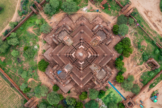 Aerial view of the symmetrical brick architecture of Dhammayangyi Temple surrounded by lush green trees and ancient walls in Old Bagan Mandalay Region Myanmar Burma. Aerial view of the symmetrical brick architecture of Dhammayangyi Temple surrounded by lush green trees and ancient walls in Old Bagan Mandalay Region Myanmar Burma.