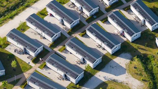 Aerial view of modern holiday homes with solar panels arranged in neat rows with paved pathways and green surroundings in Venlo Limburg Netherlands. Aerial view of modern holiday homes with solar panels arranged in neat rows with paved pathways and green surroundings in Venlo Limburg Netherlands.