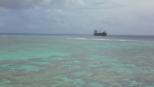 Aerial view of a cargo ship anchored in a lagoon Cook Islands. Aerial view of a cargo ship anchored in a lagoon Cook Islands.