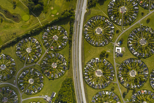 Aerial view of the unique circular garden allotments of Haveforeningen Harekaer with small houses and green lawns divided by a road in Brondby Denmark. Aerial view of the unique circular garden allotments of Haveforeningen Harekaer with small houses and green lawns divided by a road in Brondby Denmark.