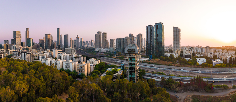 Aerial view of the modern skyline featuring high rise buildings urban architecture and lush green trees during sunset in Tel Aviv Yafo Tel Aviv District Israel. Aerial view of the modern skyline featuring high rise buildings urban architecture and lush green trees during sunset in Tel Aviv Yafo Tel Aviv District Israel.