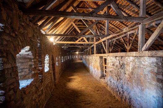 View of the historic wooden roof structure and stone walls inside the fortified church of Prejmer Brasov Romania. View of the historic wooden roof structure and stone walls inside the fortified church of Prejmer Brasov Romania.