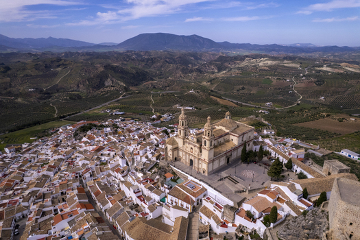 Aerial view of the Church of Our Lady of the Incarnation surrounded by white washed houses terracotta rooftops and olive groves in Olvera Andalusia Spain. Aerial view of the Church of Our Lady of the Incarnation surrounded by white washed houses terracotta rooftops and olive groves in Olvera Andalusia Spain.