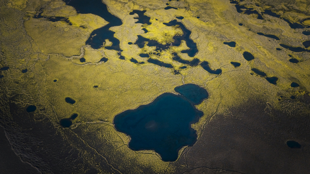 Aerial view of abstract patterns formed by small dark blue lakes and vibrant green mossy terrain in the volcanic landscape of Langisjor Vik Myrdalshreppur Iceland. Aerial view of abstract patterns formed by small dark blue lakes and vibrant green mossy terrain in the volcanic landscape of Langisjor Vik Myrdalshreppur Iceland.