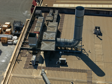 Aerial view of industrial ventilation systems and exhaust stacks on a corrugated metal rooftop in Kilsyth Victoria Australia. Aerial view of industrial ventilation systems and exhaust stacks on a corrugated metal rooftop in Kilsyth Victoria Australia.