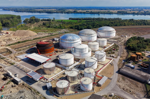 Aerial view of fuel tanks at a storage facility with pipelines and a river in the background in Kovin Vojvodina Serbia. Aerial view of fuel tanks at a storage facility with pipelines and a river in the background in Kovin Vojvodina Serbia.