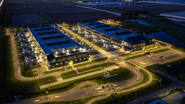 Aerial view of the Microsoft Data Center illuminated at night featuring large industrial buildings parking areas and surrounding landscape in Middenmeer North Holland Netherlands.