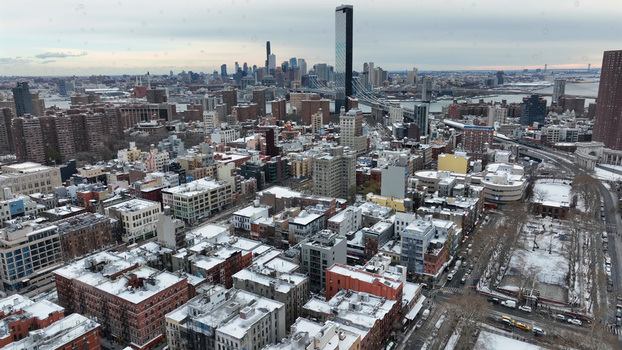 Aerial view of the Manhattan skyline in winter with snow covered rooftops dense urban architecture and city streets in New York New York United States. Aerial view of the Manhattan skyline in winter with snow covered rooftops dense urban architecture and city streets in New York New York United States.