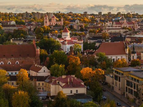 Aerial view of the old town with its terracotta roofs and baroque churches including St. Anne s and St. Francis of Assisi Church bathed in the warm glow of the setting sun Vilnius Lithuania. Aerial view of the old town with its terracotta roofs and baroque churches including St. Anne s and St. Francis of Assisi Church bathed in the warm glow of the setting sun Vilnius Lithuania.