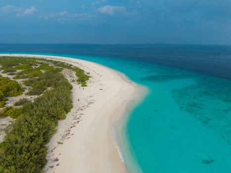 Aerial view of a white sand beach vibrant turquoise ocean and deep blue sea with green trees Hoarafushi Thiladhunmathee Uthuruburi Maldives. Aerial view of a white sand beach vibrant turquoise ocean and deep blue sea with green trees Hoarafushi Thiladhunmathee Uthuruburi Maldives.