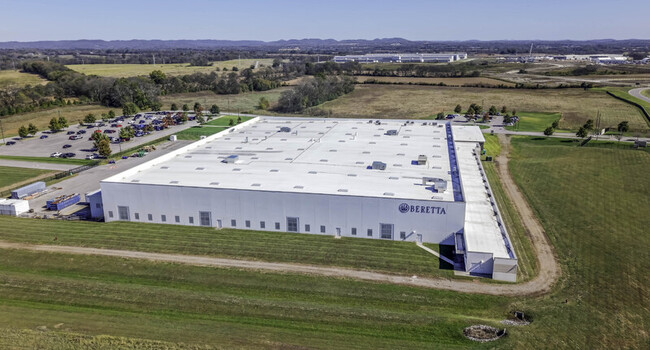 Aerial view of the Beretta USA manufacturing facility with its large white roof surrounding parking area and adjacent grassy fields in Gallatin TN United States. Aerial view of the Beretta USA manufacturing facility with its large white roof surrounding parking area and adjacent grassy fields in Gallatin TN United States.