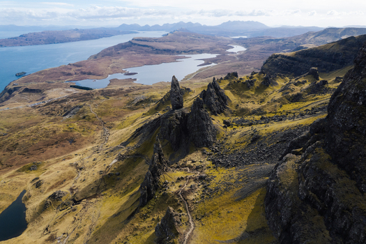 Aerial view of The Storr a dramatic rocky landscape with jagged basalt pinnacles winding hiking trails and expansive views in Portree Scotland United Kingdom. Aerial view of The Storr a dramatic rocky landscape with jagged basalt pinnacles winding hiking trails and expansive views in Portree Scotland United Kingdom.