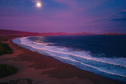 Aerial view of Playa Punta Perula at night with a full moon illuminating the dark ocean waves and sandy coastline in Perula Jalisco Mexico. Aerial view of Playa Punta Perula at night with a full moon illuminating the dark ocean waves and sandy coastline in Perula Jalisco Mexico.