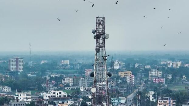 Aerial view of a telecommunications tower over a city. Aerial view of a telecommunications tower over a city.