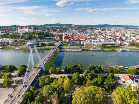 Aerial view of the Most SNP bridge and Bratislava Castle overlooking the Danube River and the historic city center under a blue sky in Bratislava Bratislava Region Slovakia. Aerial view of the Most SNP bridge and Bratislava Castle overlooking the Danube River and the historic city center under a blue sky in Bratislava Bratislava Region Slovakia.