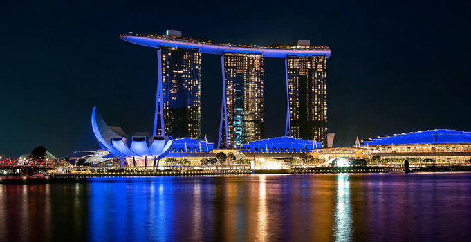 Aerial view of the ArtScience Museum and Marina Bay Sands illuminated at night reflecting in the calm waters of the bay in Singapore Singapore. Aerial view of the ArtScience Museum and Marina Bay Sands illuminated at night reflecting in the calm waters of the bay in Singapore Singapore.