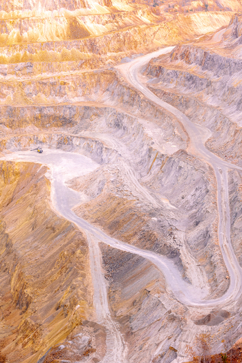 Geamana Romania 21 September 2026 Aerial view of the vast open pit mine in Geamana with winding dirt roads steep terraced slopes and exposed yellow and grey mineral earth. Geamana Romania 21 September 2026 Aerial view of the vast open pit mine in Geamana with winding dirt roads steep terraced slopes and exposed yellow and grey mineral earth.