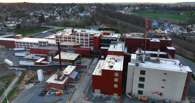 Aerial view of a large industrial manufacturing facility with red and beige buildings parking areas and surrounding landscape in Elizabethtown Pennsylvania United States. Aerial view of a large industrial manufacturing facility with red and beige buildings parking areas and surrounding landscape in Elizabethtown Pennsylvania United States.