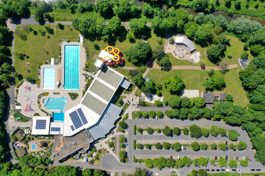 Aerial view of Konigsbad Forchheim featuring outdoor swimming pools colorful water slides and lush green parkland in Forchheim Bayern Germany. Aerial view of Konigsbad Forchheim featuring outdoor swimming pools colorful water slides and lush green parkland in Forchheim Bayern Germany.